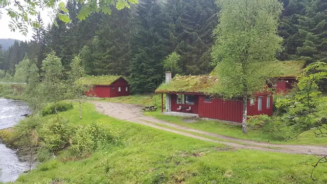 Hytte med torvtak ved elva